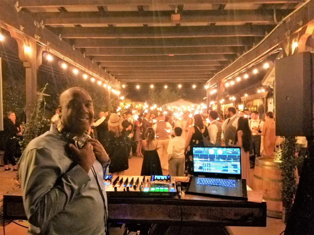 DJ SouthLAnd at his booth during a wedding sparkler celebration.