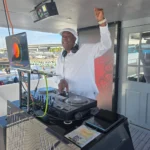 DJ SouthLAnd performing in white attire at a yacht party.